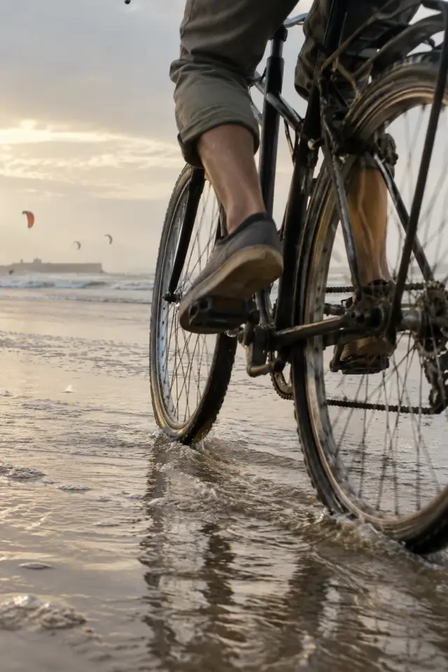 Un vélo roule sur le sable dur au bord de l'eau