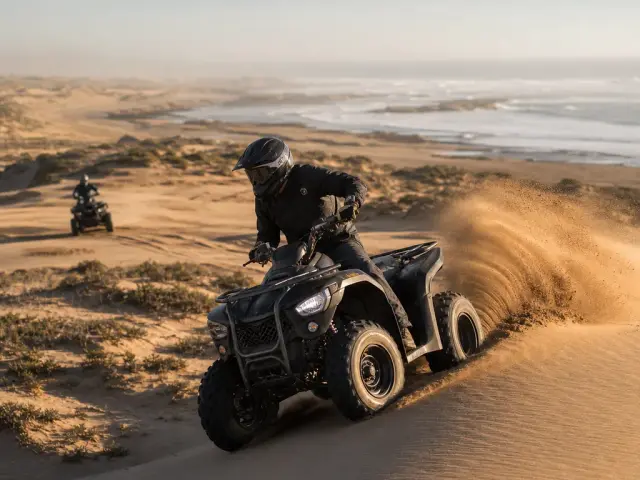 Un pilote de quad soulève le sable dans les dunes près d'Essaouira