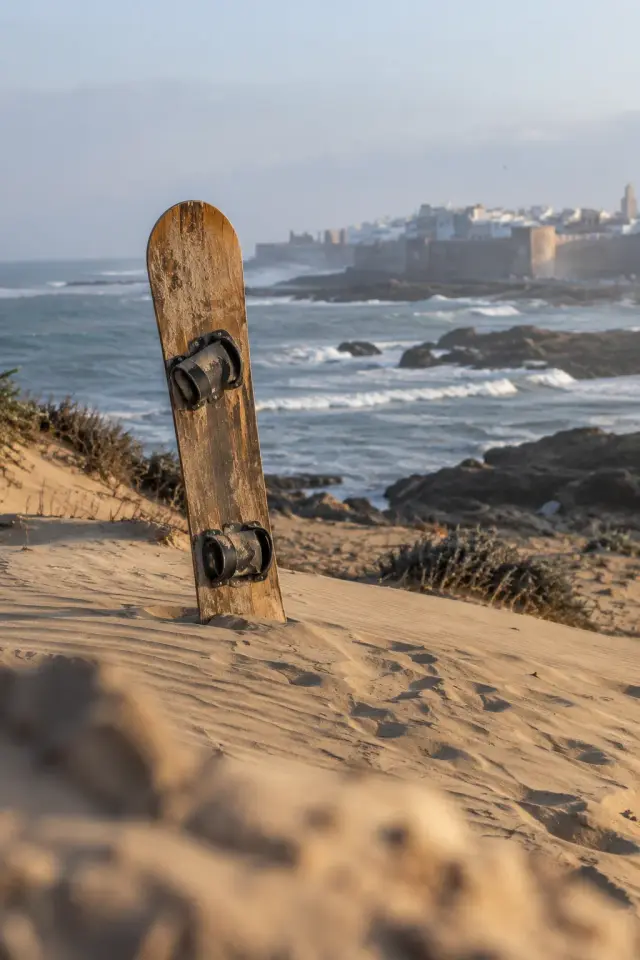 Une planche de sandboard plantée sur la crête d'une dune